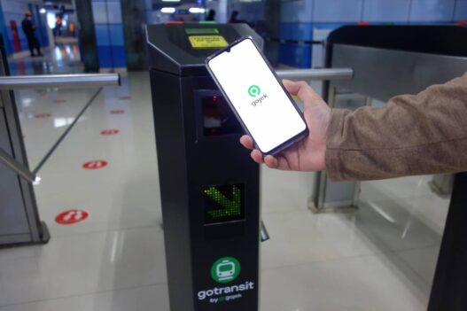 Pengguna KRL memindai QR GoPay di gate stasiun