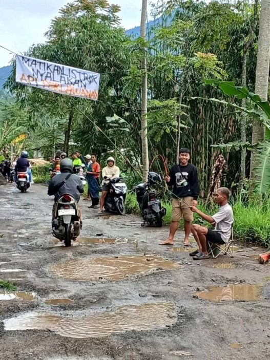 Warga Asyik "Mancing" di Jalan Bolong